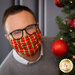 Man with glasses wearing red cloth face mask peeking around a tree