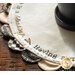 The edge of the Welcome Home Scalloped Table Topper on a dark brown table