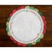 Christmas themed round scalloped table topper on a wood background