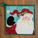 Better Not Pout Santa Pot Holder laid flat on a wood background