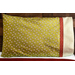 Bright green pillowcase with monkeys and a fun accent stripe resting on a bed