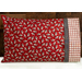 Bright red pillowcase with cows and a fun accent stripe resting on a bed