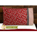 Bright red pillowcase with cows and a fun accent stripe resting on a bed