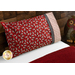 Bright red pillowcase with cows and a fun accent stripe resting on a bed