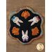 Adorable scalloped wool mat with bunnies and carrot bundles on a wood table