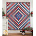 Red, white, and blue diamond patterned quilt hung from a wall