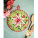 Green floral circular hot pad laid flat on a light teal table