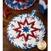 The coordinating white and blue America the Beautiful Folded Star Hot Pads on a wood table