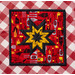 The red and yellow Peace, Love & BBQ Folded Star Squared Hot Pad on a red and white checkered table
