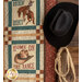 A cowboy hat and rope hung next to the Home On The Range Panel Quilt