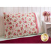 A beautiful red and white floral pillow on a bed