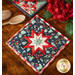 The navy Folded Star Square Hot Pad made with Sunday Stroll fabrics on a wood background