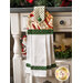 A black, red, and white Christmas hanging towel hung from a cabinet
