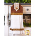 A brown and white waffle weave towel hanging from a cabinet