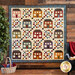 A colorful quilt with house blocks and checkered lattice designs