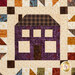 A close up of a purple house graphic on a quilt