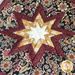 A close up of a folded star on a quilted hot pad