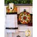 White hanging towel with rich earth toned grape pattern next to matching hot pad.