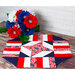 A patriotic table topper on a wood desk next to red, white, and blue flowers