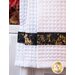 Close up of waffle textured white towel with black and gold band.
