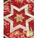 A folded star design on a hot pad with red and pink floral fabrics.
