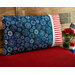 A patriotic pillowcase featuring bursting fireworks propped up against a wood wall 