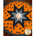 Hot pad with central folded star and orange fabric featuring black cat faces.