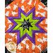 Square hot pad with central folded star design featuring Halloween themed fabrics.