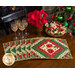 Six Christmas themed placemats on wood table next to wine glasses, poinsettias, and matching cloth napkins. 