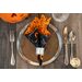 orange and black Halloween themed cloth napkin on plate setting.