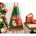 Photo of the Peppermint Candy apron hanging on a wall next to a counter with the Santa's Little Helper bag, peppermint candy mug of hot cocoa, and candy cane hearts on top and a decorated christmas tree on the other side