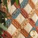 Quilt block featuring earth tones and fabrics printed with cowboy themed imagery.