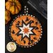 Halloween themed round hot pad with central folded star design with orange fabric featuring black cats.