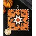 Halloween themed square hot pad with central folded star design with orange fabric featuring black cats.
