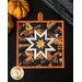 Halloween themed square hot pad with central folded star design with black fabric featuring phrases, Jack-o-lanterns, and witches.