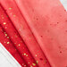 A red/pink ombre fabric with metallic accents.