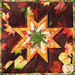 Square hot pad with autumn leaf motifs and central folded star design made with burgundy fabrics sitting on wood table.