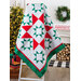 A white quilt with red and green geometric square and triangle designs.