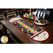 Christmas themed table runner featuring phrases, ornaments, and snowflakes, designed with rounded sides and central pinwheels.
