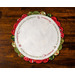 Christmas themed round scalloped table topper on a wood background