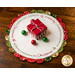 Round scalloped Christmas themed table topper with a gift box and ornaments on top