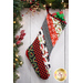 Hanging holiday stocking made from strips of Christmas themed fabric in red, black, and white.