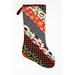 Hanging holiday stocking made from strips of Christmas themed fabric in red, black, and white.