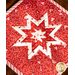 Red squared hot pad with folded star design made of red and pink Valentine's Day themed fabrics.