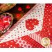 Diamond star designed table topper with strips of Valentine's day printed fabrics and appliqué hearts.