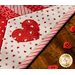 Diamond star designed table topper with strips of Valentine's day printed fabrics and appliqué hearts.