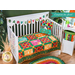Multi colored quilt with jungle animals and geometric designs draped over furniture.