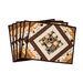 Coffee themed placemats made of brown, tan, and cream fabrics with coffee cups in the center surrounded by strips of fabric in a diamond shape.