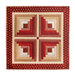 Wall hanging with four squares made up of strips of red and cream floral and geometric fabric prints.