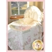 A pastel pink and green on white baby quilt in traditional bassinet.